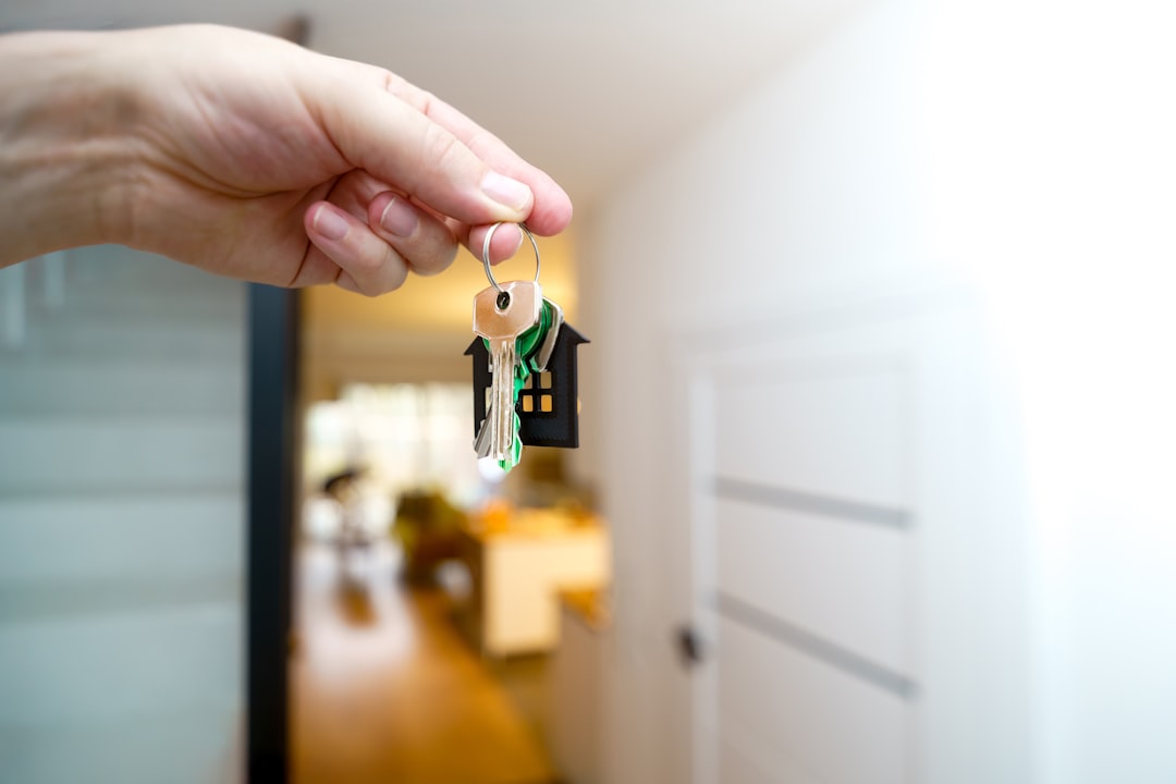 A person's hands holding two distinct sets of house keys against a clean background, illustrating the decision between real estate commission options.