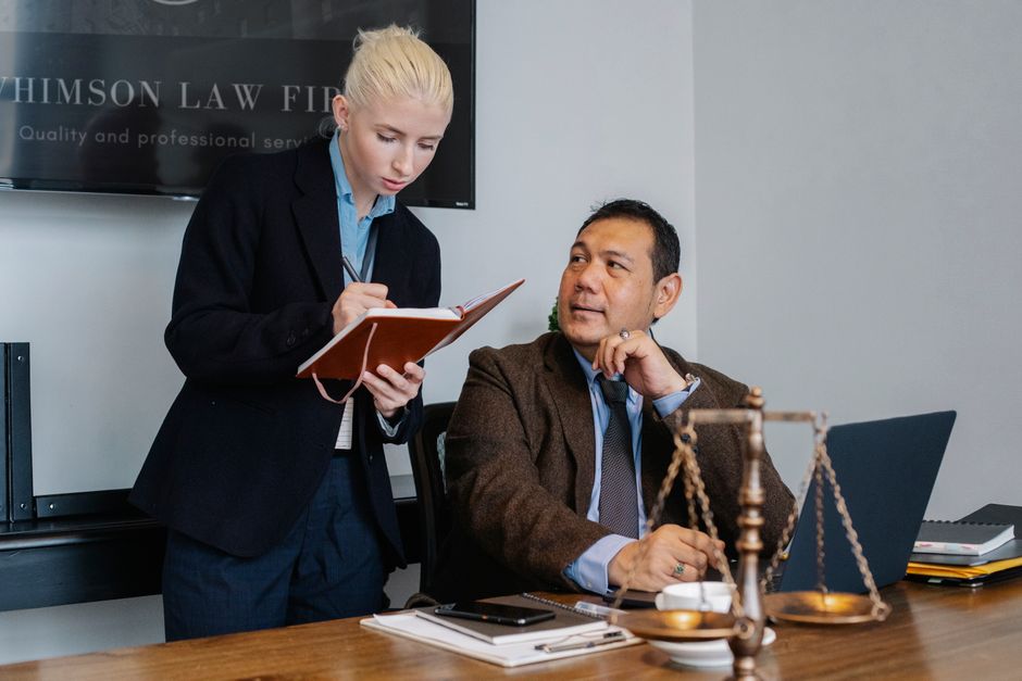 Bright, modern law office interior with a sleek laptop open on a desk, symbolizing the integration of technology in the le...