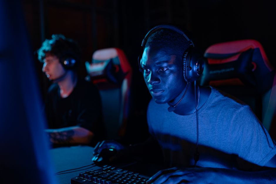 A person's face illuminated by a computer screen in a dark room, showing intense focus while searching for legal help online.