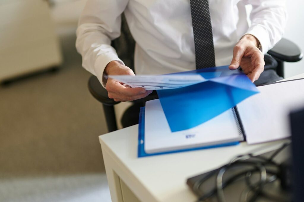 Professional person sits at a modern desk in their home, thoughtfully reviewing a stack of documents, representing an STR ...